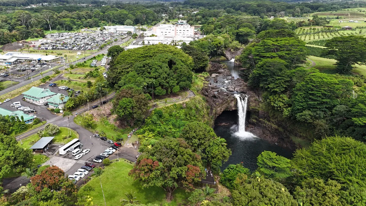 An aerial view of the Rainbow Falls overlook and parking area, showing how close this hilo waterfall photo spot sits to downtown Hilo, Hawaii